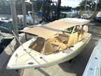 Beige Scout center console boat with a custom tan National Canvas sun shade at the dock