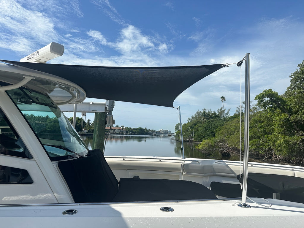 Black custom sun shade over a white center console boat on the intracoastal