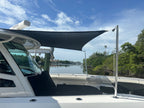 Black custom sun shade over a white center console boat on the intracoastal
