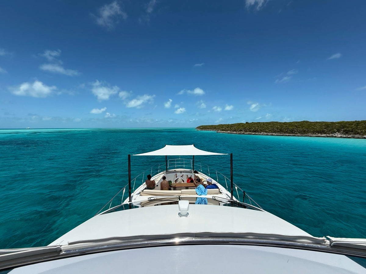 Custom foredeck Sunshade over the bow seating of a motor yacht anchored in the Bahamas